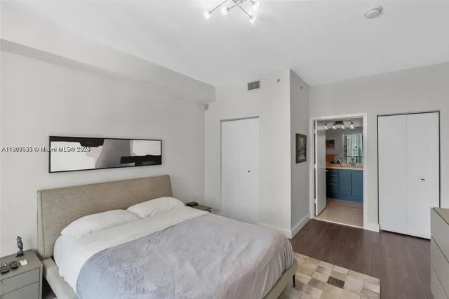 a bedroom with a large bed and wooden floor