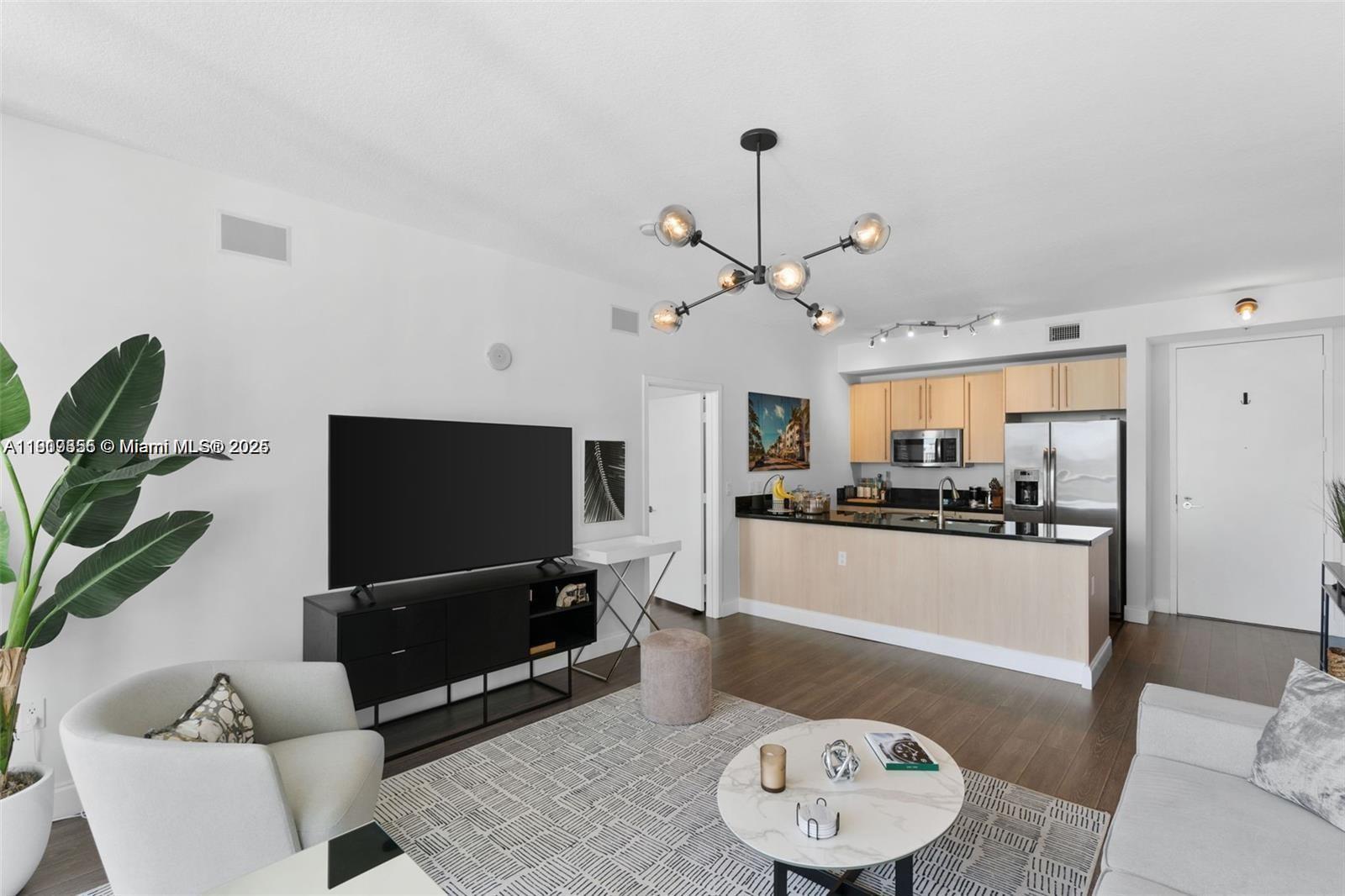 79 Southwest 12th Street, Unit 2204S Miami, FL 33130 - Photo 9 of 27 a living room with furniture and a flat screen tv