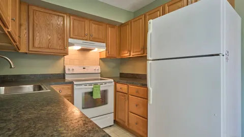 a kitchen with granite countertop a refrigerator sink and cabinets