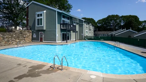 a view of backyard with large tree and wooden fence