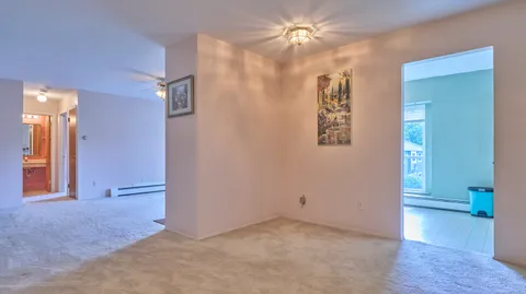 an empty room with closet and a chandelier fan