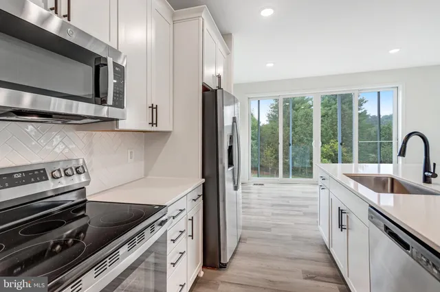 a kitchen with a sink and stainless steel appliances