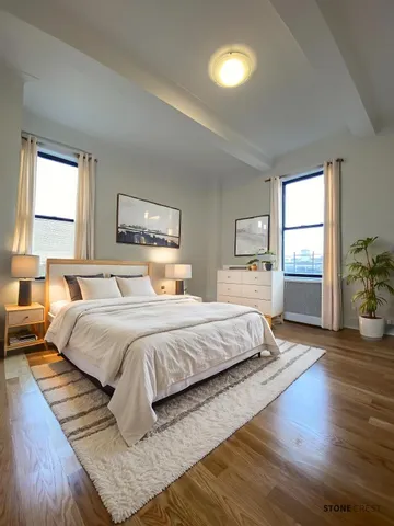 a spacious bedroom with a large bed and wooden floor