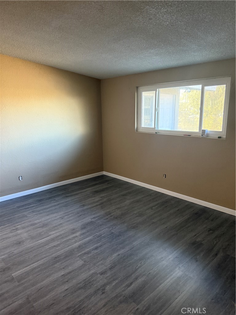 6030 Ocotillo Avenue Twentynine Palms, CA 92277 - Photo 7 of 10 a view of an empty room with wooden floor and a window