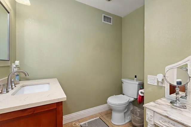 a bathroom with a toilet sink vanity and mirror