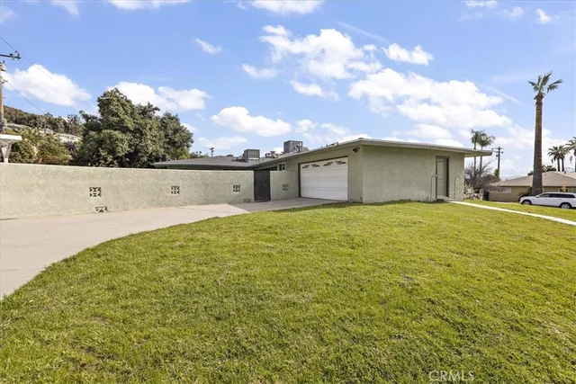 a living room with stainless steel appliances furniture a rug and a clock