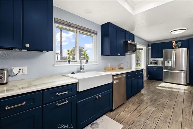 a kitchen with a sink a refrigerator and wooden cabinets