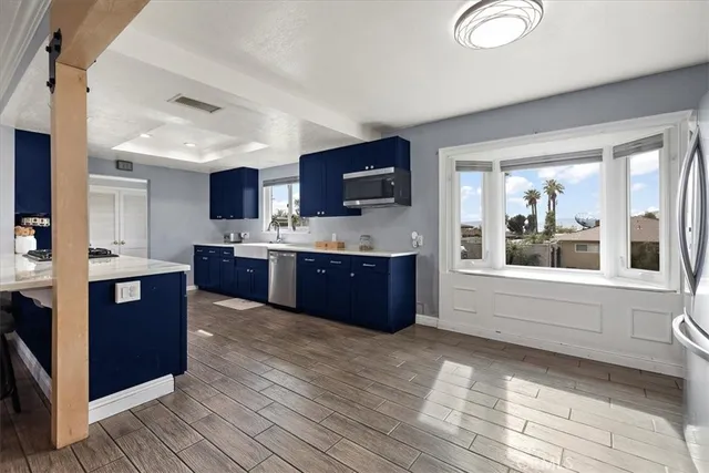 a large kitchen with stainless steel appliances granite countertop a large counter top a stove and a refrigerator