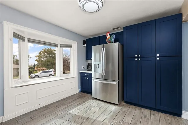 a kitchen with a refrigerator and wooden floors