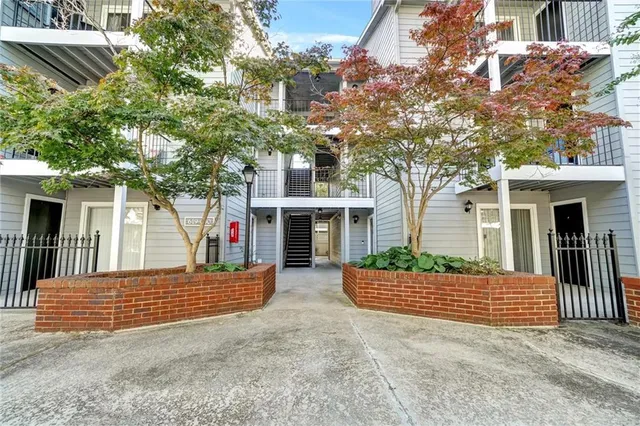 a view of a house with a yard and potted plants