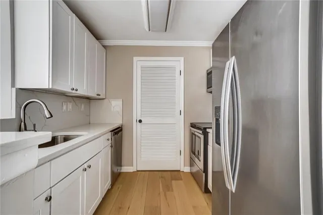 a view of a kitchen with sink and refrigerator