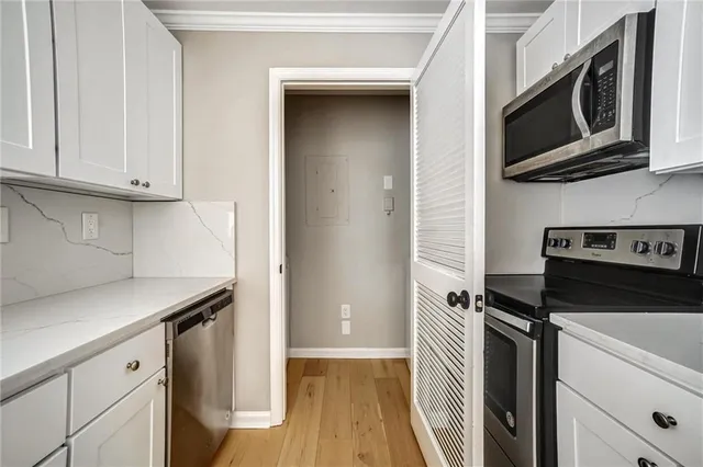 a kitchen with stainless steel appliances white cabinets and a stove