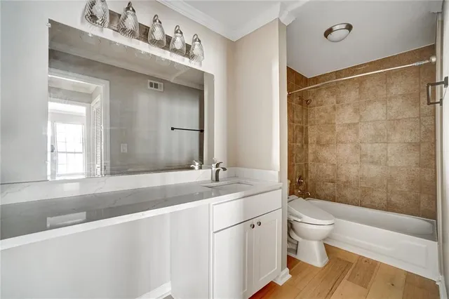 a bathroom with a sink vanity granite toilet tub and shower