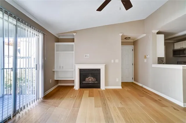 a view of an empty room with window and fire place