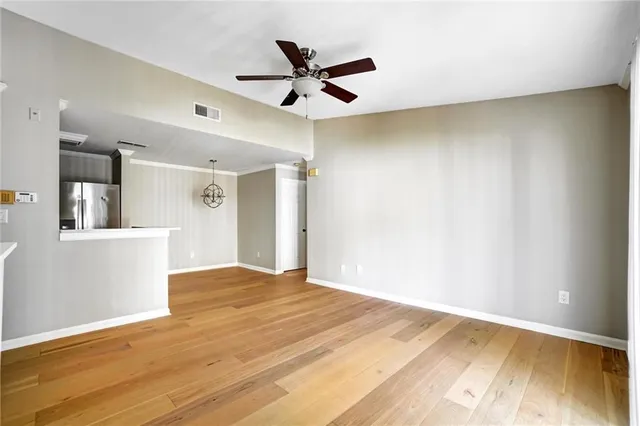 a view of a livingroom with a ceiling fan and wooden floor