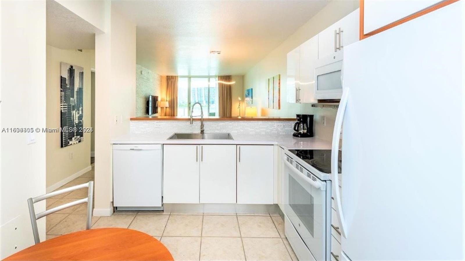 18100 North Bay Road, Unit 606 Sunny Isles Beach, FL 33160 - Photo 11 of 30 a kitchen with stainless steel appliances a refrigerator sink and cabinets