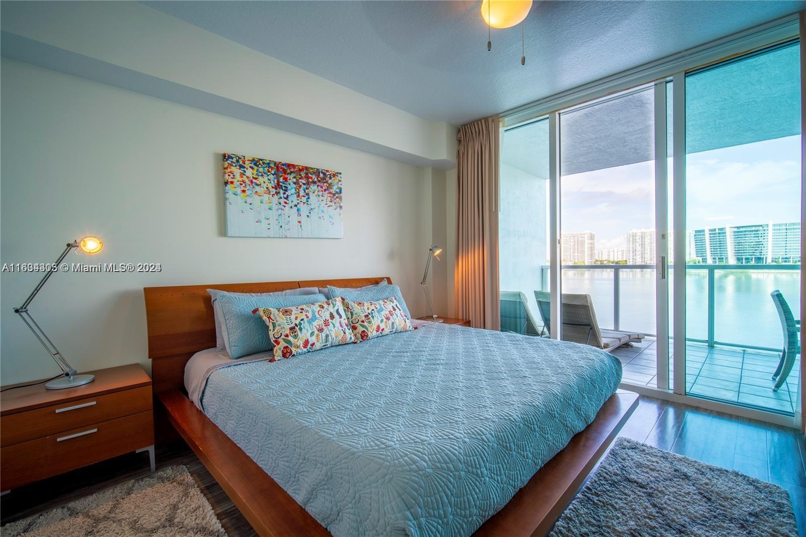 18100 North Bay Road, Unit 606 Sunny Isles Beach, FL 33160 - Photo 12 of 30 a bedroom with a bed and glass window