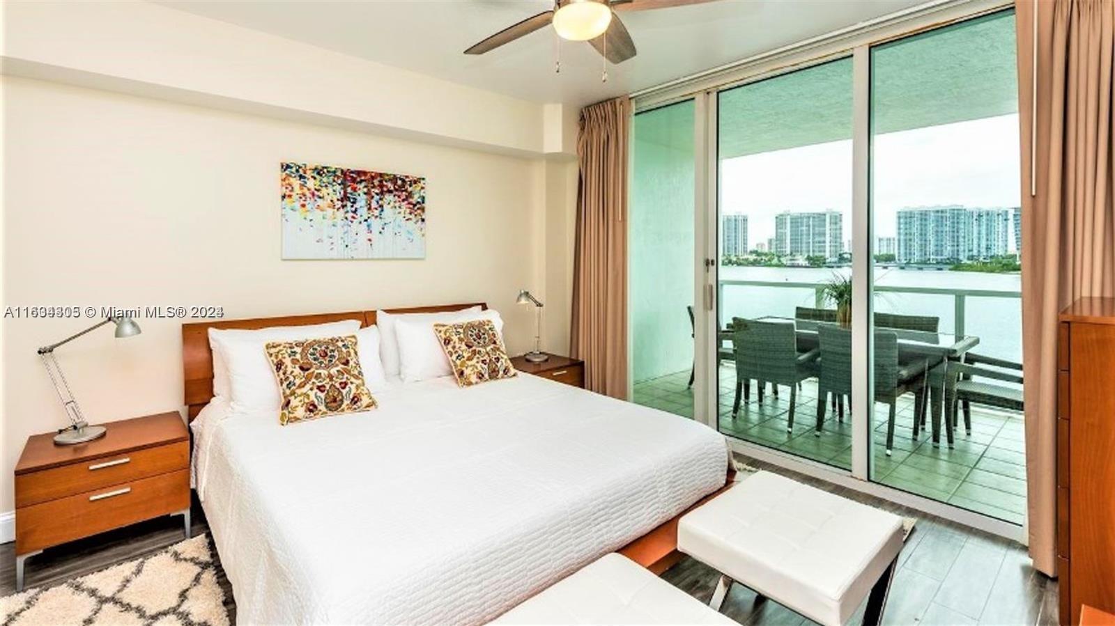 18100 North Bay Road, Unit 606 Sunny Isles Beach, FL 33160 - Photo 14 of 30 a bedroom with a bed and a large window