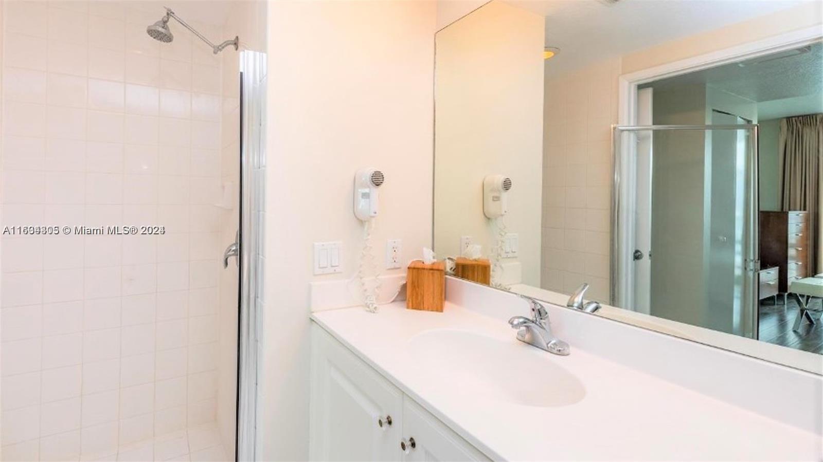 18100 North Bay Road, Unit 606 Sunny Isles Beach, FL 33160 - Photo 19 of 30 a bathroom with a sink and a mirror