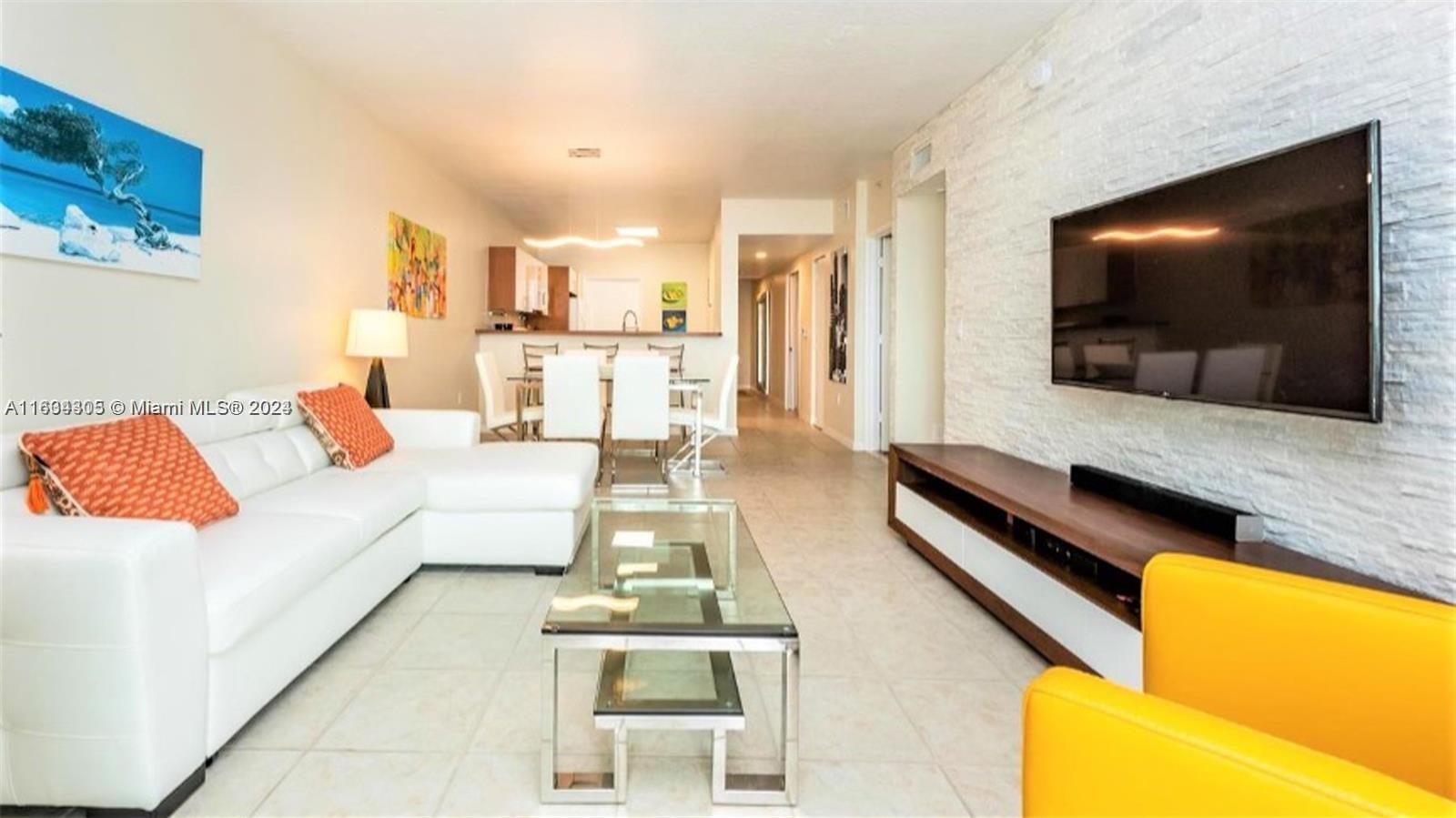 18100 North Bay Road, Unit 606 Sunny Isles Beach, FL 33160 - Photo 2 of 30 a living room with furniture and a flat screen tv