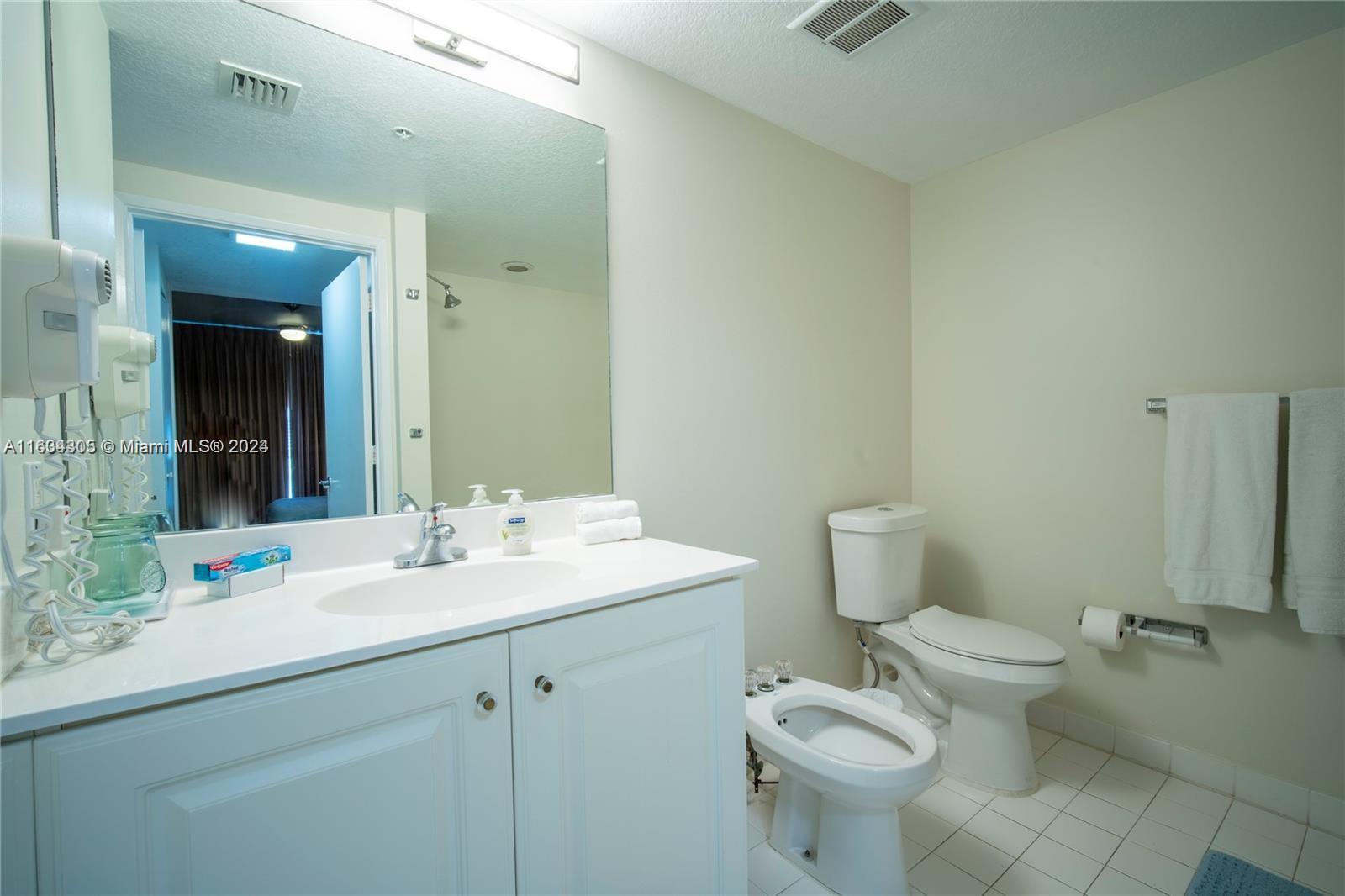 18100 North Bay Road, Unit 606 Sunny Isles Beach, FL 33160 - Photo 21 of 30 a bathroom with a sink toilet and shower