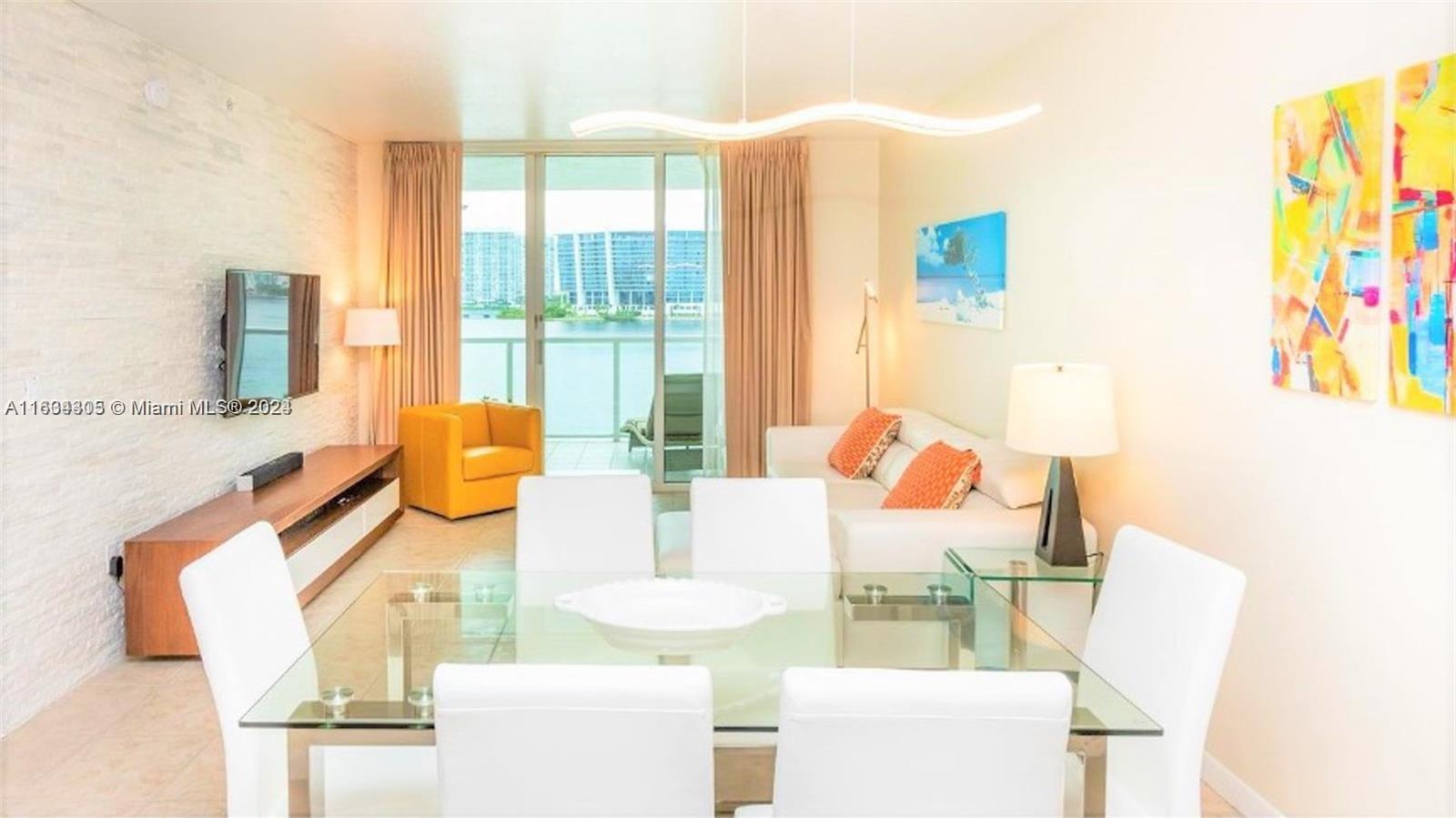 18100 North Bay Road, Unit 606 Sunny Isles Beach, FL 33160 - Photo 3 of 30 a living room with furniture and a table