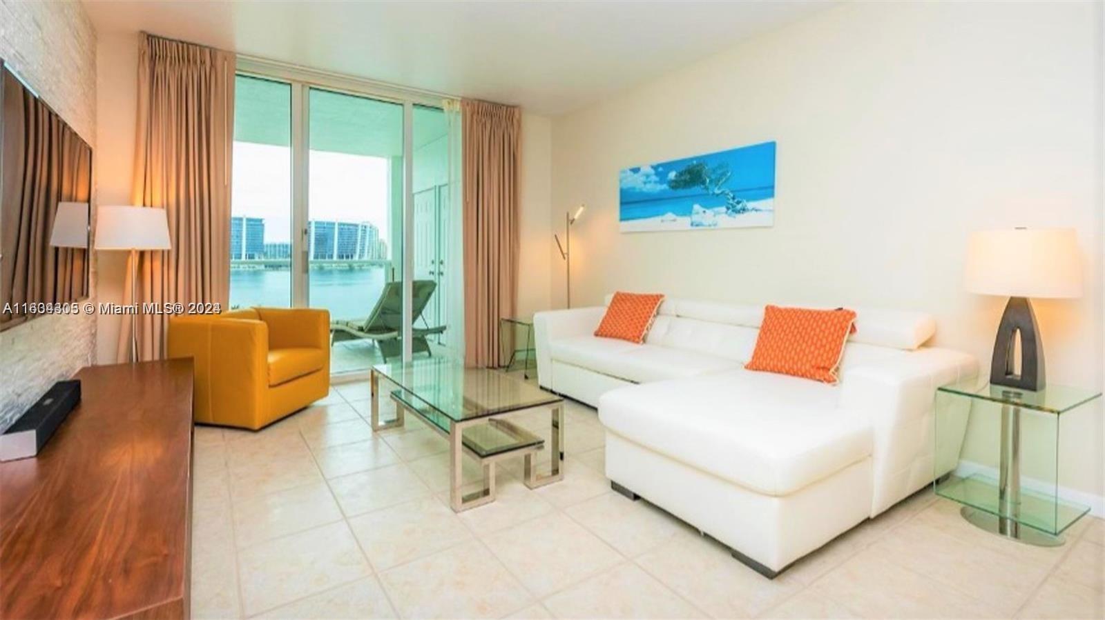 18100 North Bay Road, Unit 606 Sunny Isles Beach, FL 33160 - Photo 4 of 30 a living room with furniture and a large window