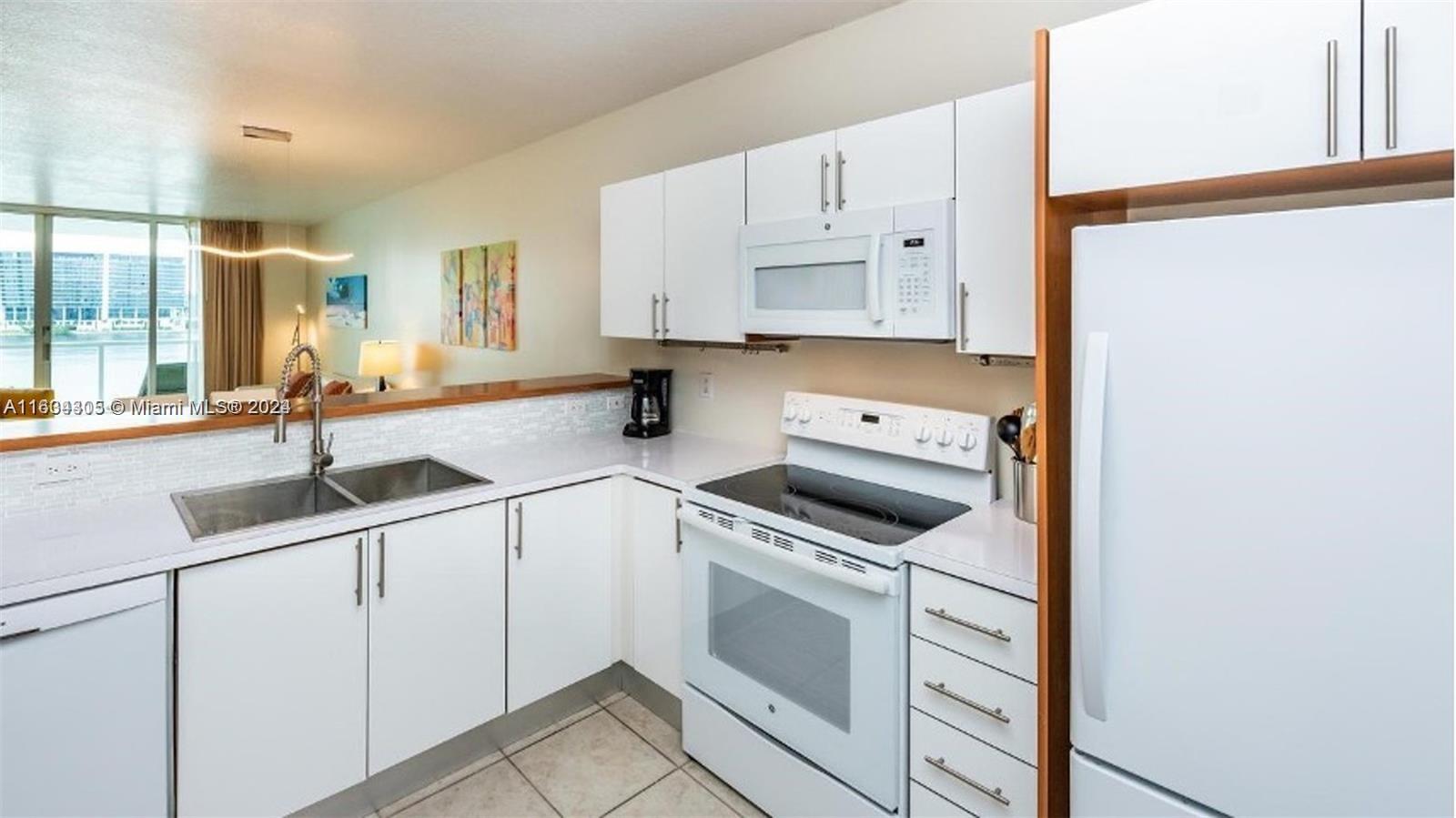 18100 North Bay Road, Unit 606 Sunny Isles Beach, FL 33160 - Photo 9 of 30 a kitchen with granite countertop a sink stainless steel appliances and cabinets