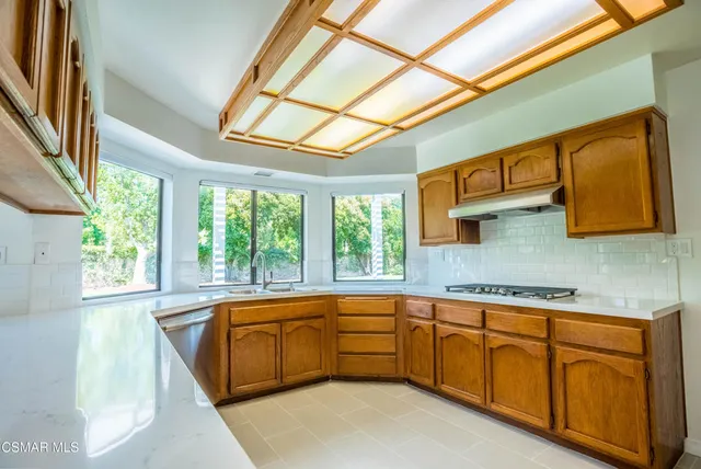 a large white kitchen with a large window and sink