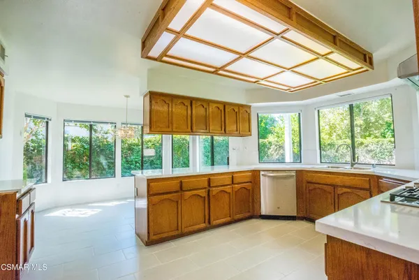 a kitchen with stainless steel appliances a sink and a large window