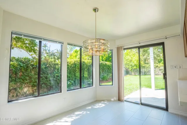 a view of an empty room with windows and chandelier