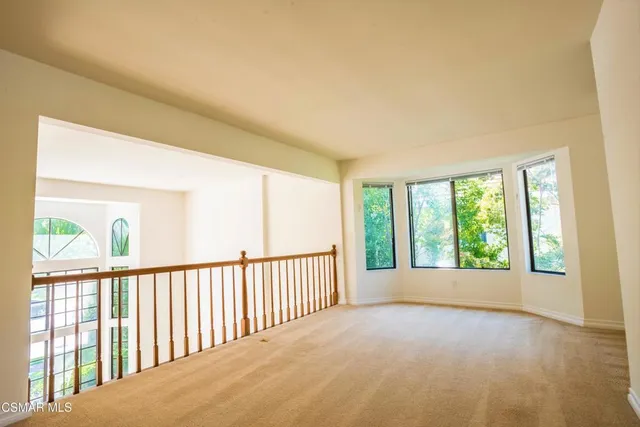 a view of a big room with wooden floor and windows
