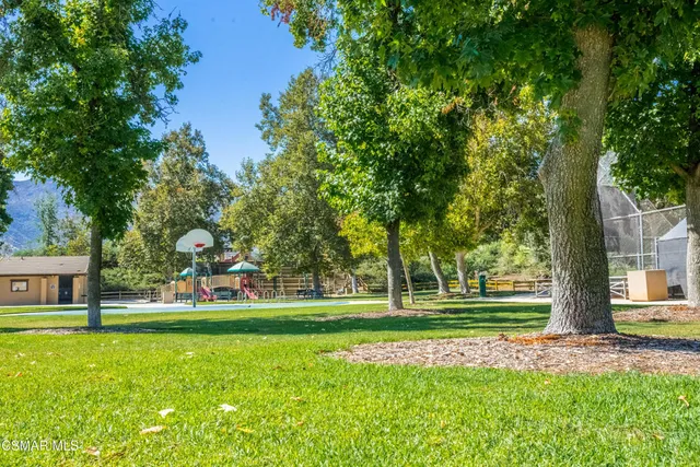 a view of a white house with a big yard and potted plants