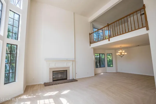 a view of an empty room with fireplace and a window