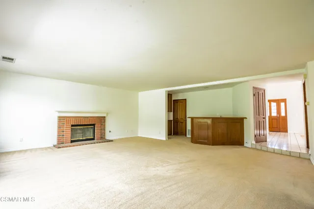 an empty room with a fireplace and wooden floor
