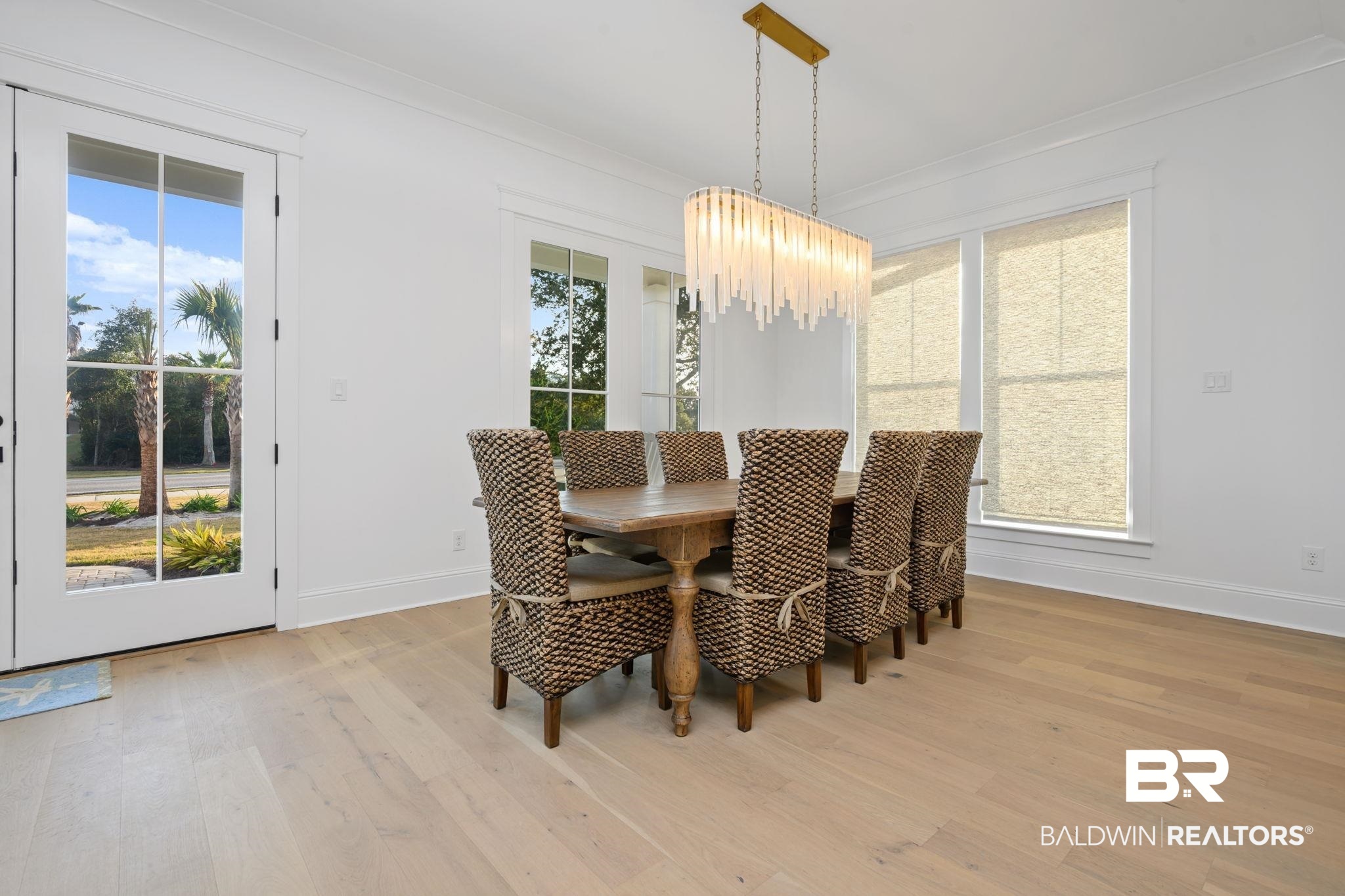 30313 River Road Orange Beach, AL 36561 - Photo 13 of 50 Dining room with light wood-style flooring, crown molding, and a chandelier