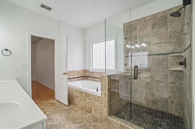 a bathroom with a tub a sink and a shower