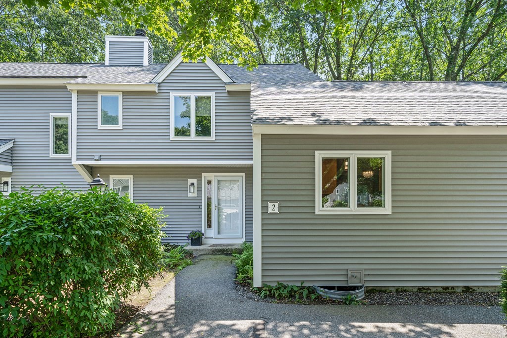 a front view of a house with a yard and trees