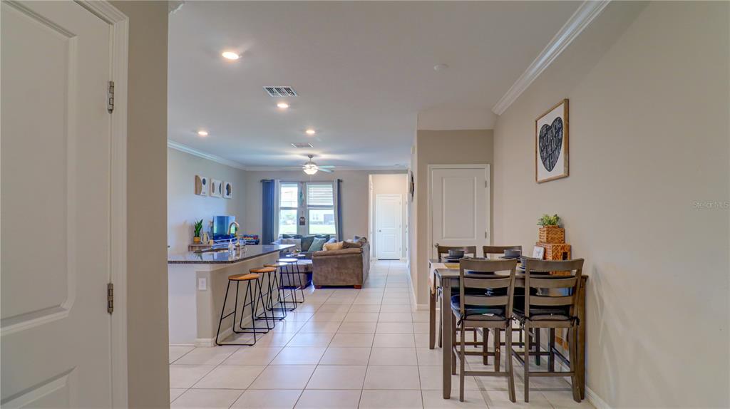 31632 Blue Passing Loop Wesley Chapel, FL 33545 - Photo 5 of 48 a room with stainless steel appliances a dining table and chairs with kitchen view