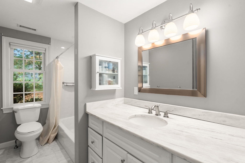 8 Jericho Road, Unit 8 Weston, MA 02493 - Photo 14 of 19 a bathroom with a granite countertop sink toilet a large mirror and a window