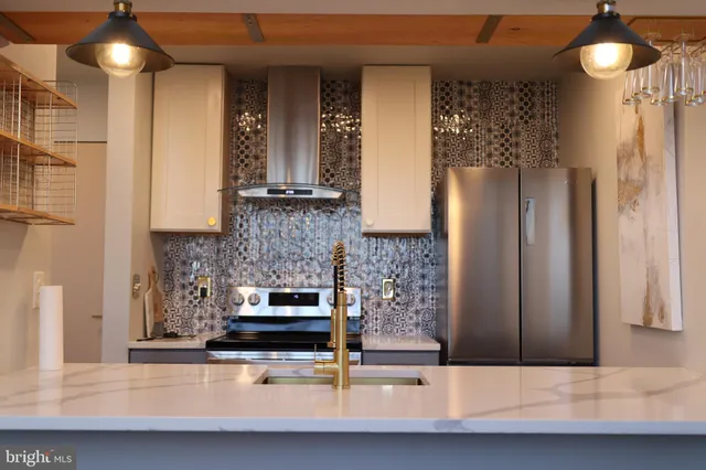 a kitchen with kitchen island granite countertop a refrigerator and a stove