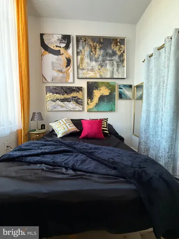 a bedroom with a bed and painting on the wall