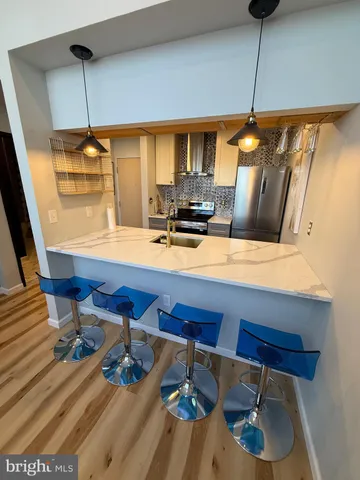 a kitchen with a table chairs and a wooden floor