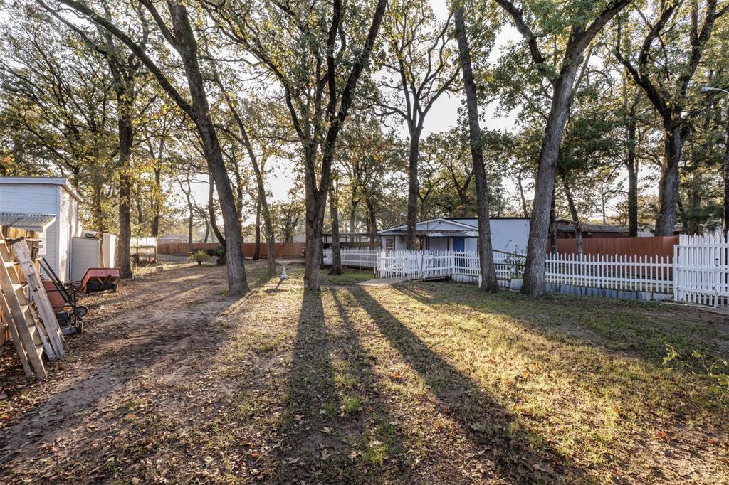 9953 Green Tree Lane Wills Point, TX 75169 - Photo 27 of 39 a view of yard with wooden fence and large trees