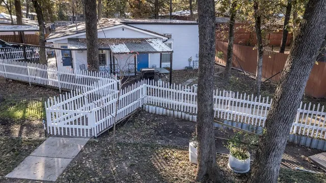 a view of a house with a small yard and wooden deck