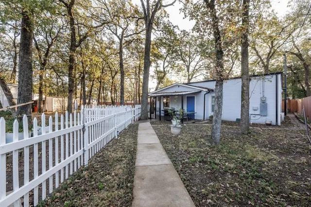 a view of house with backyard and trees
