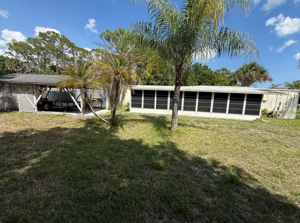 a view of a house with backyard and sitting area
