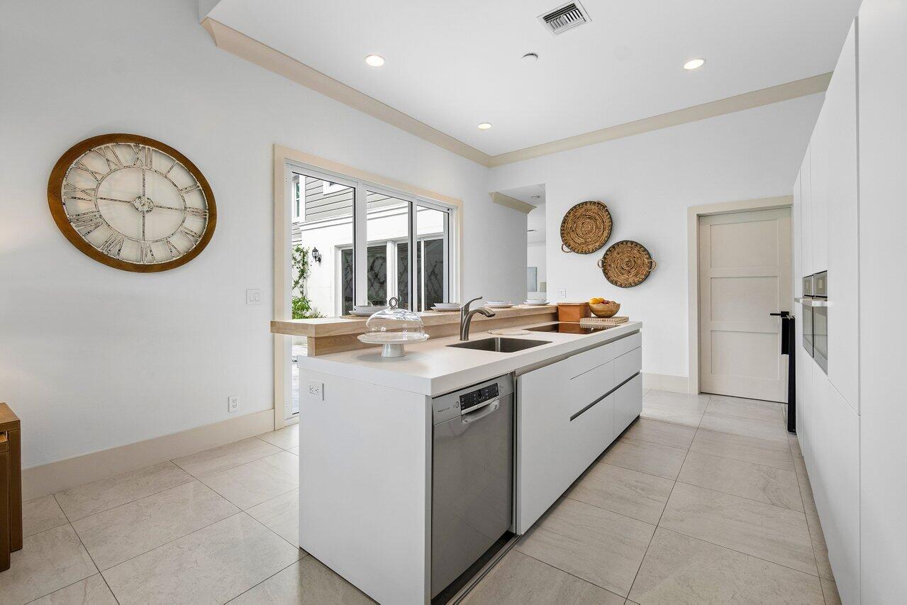 5848 Northwest 39th Avenue Boca Raton, FL 33496 - Photo 11 of 37 a large kitchen with stainless steel appliances granite countertop a stove a clock and a window