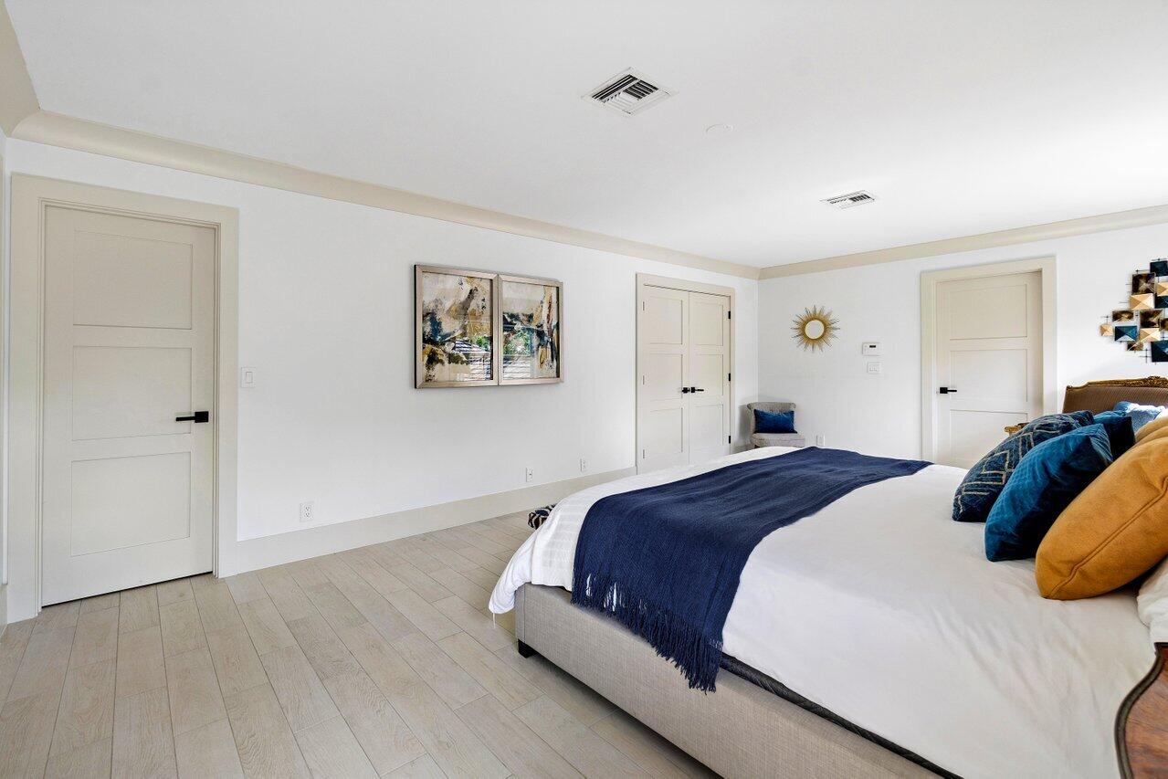 5848 Northwest 39th Avenue Boca Raton, FL 33496 - Photo 19 of 37 a bedroom with a bed and painting on the wall