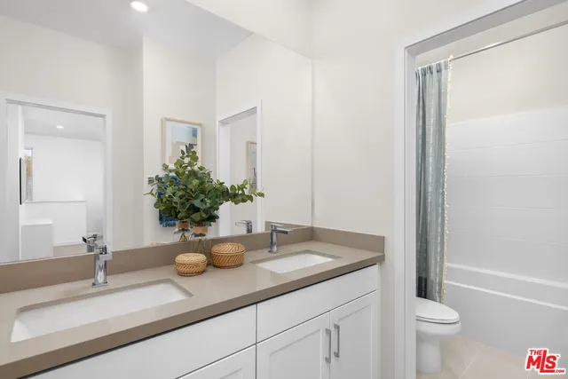 a bathroom with a granite countertop sink a toilet and a mirror